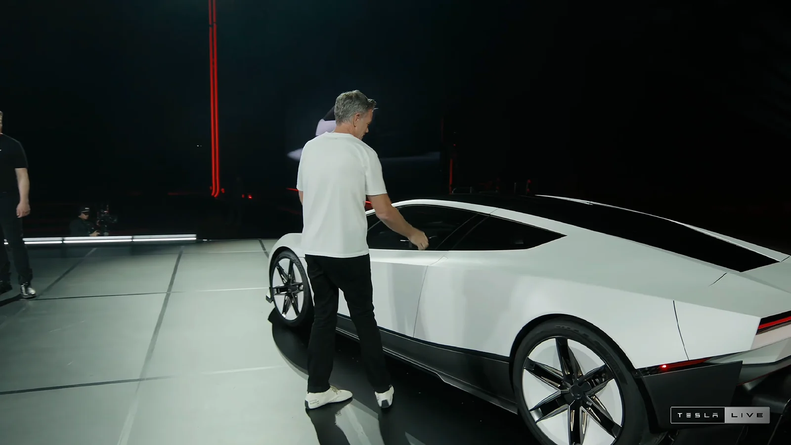 Roadster trên sân khấu: một thành viên đội ngũ mở cửa xe để giới thiệu. Ảnh: khung hình từ buổi phát trực tiếp Tesla Live ngày 15/10/2026