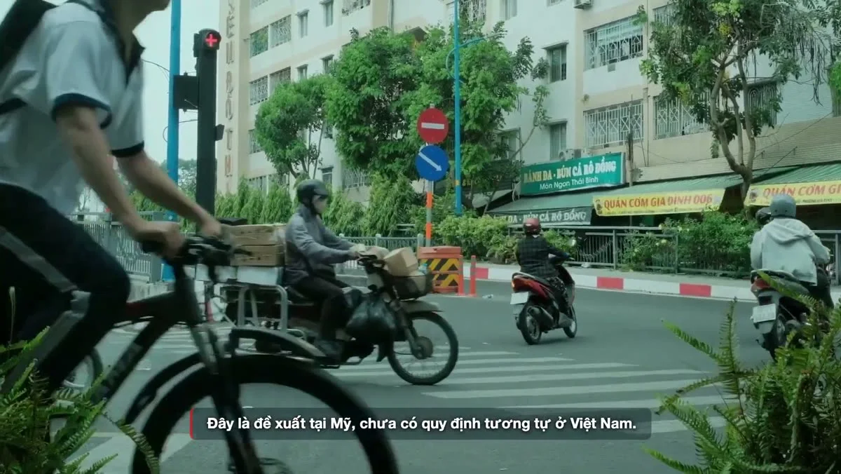 Xe máy và xe đạp chạy qua một ngã tư có đèn tín hiệu trên phố Việt Nam. Ảnh: khung hình từ video TC Motion